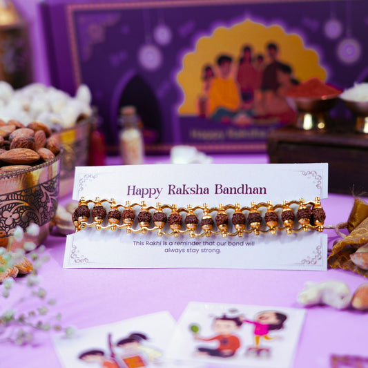Rudraksha bracelet Rakhi with golden caps and festive background for Raksha Bandhan celebration.